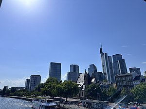 View of the Frankfurt skyline from the Main riverbank on a sunny afternoon during a break from the DACED Annual Conference 2026. (Copyright: Simon Lattke)